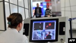 Macedonia - A health worker scans passengers with a thermal imaging camera upon their arrival at the Alexander the Great airport near Macedonia's capital Skopje on October 10, 2014